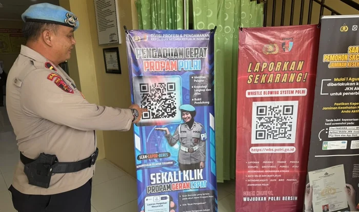 LAPORKAN OKNUM POLISI - Anggota Propam Polri Polres Malinau saat menujukan kode QR aduan kepada oknum anggota Polri "nakal". (NARASIDIKSI.COM)